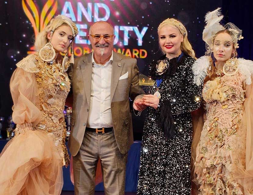 Η Ιωάννα Τζάνη με τον Antonio Bilancio (Πρόεδρος της Παγκόσμιας Συνομοσπονδίας Κομμωτικής Τέχνης CMC World) ανάμεσα στα μοντέλα του show της